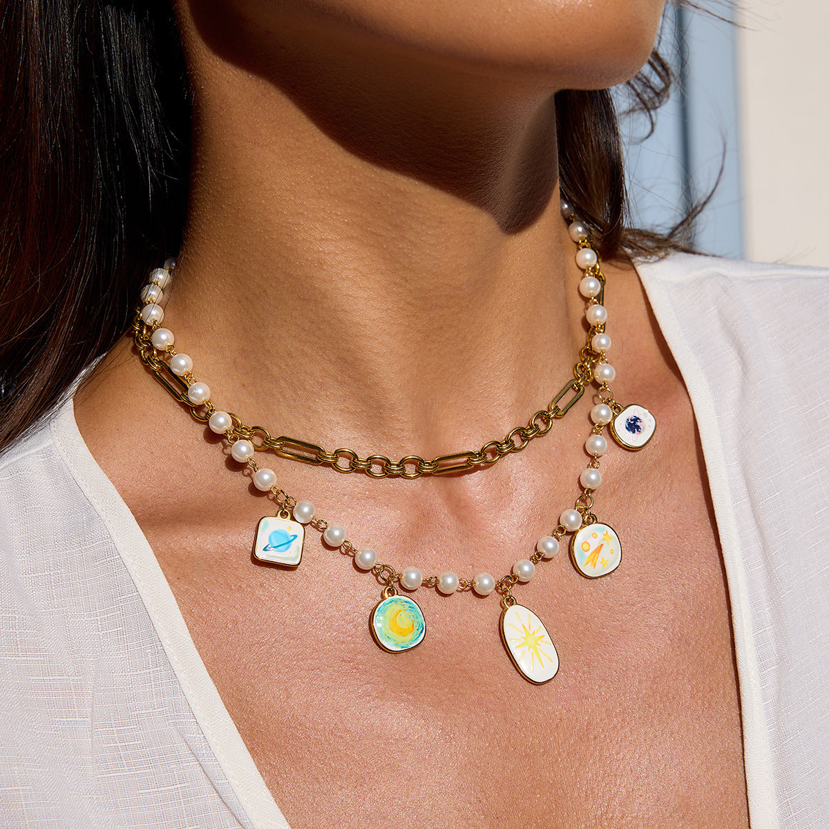 Young woman wearing celestial-themed pearl necklace in sunlight, summer-ready look