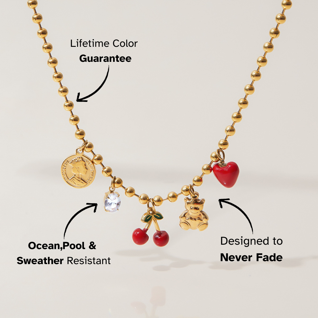 Close-up of red enamel heart and teddy bear charm necklace
