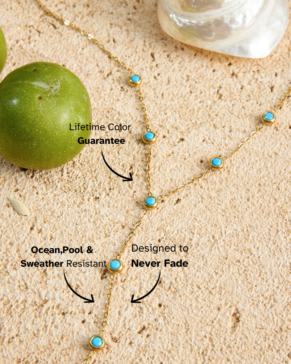 Gold necklace with turquoise stones on sand next to a green apple, with text about color guarantee and resistance.