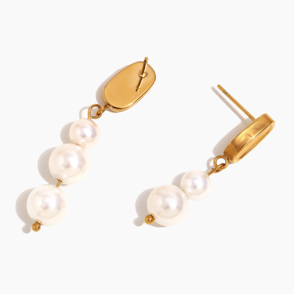Dainty pearl drop earrings paired with minimalist gold jewelry