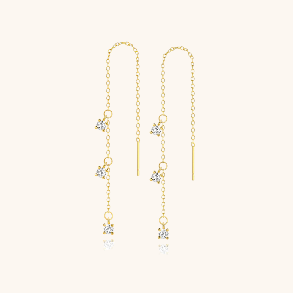 Gold threader earrings with crystal charms displayed on soft cream background