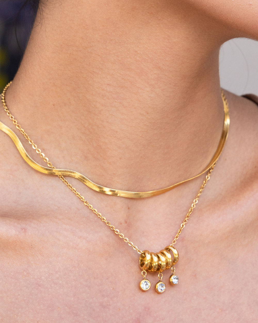 Gold necklace with beads on a person's neck