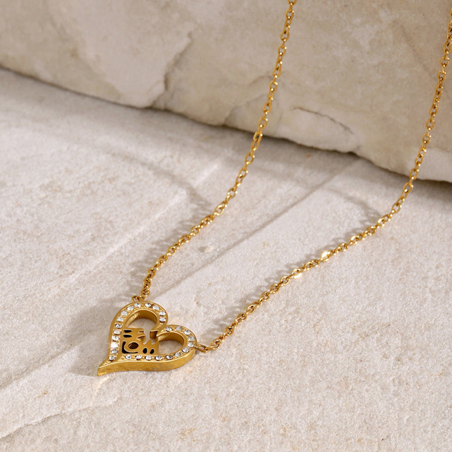 Minimalist MOM necklace with heart charm and crystals, styled on marble stone