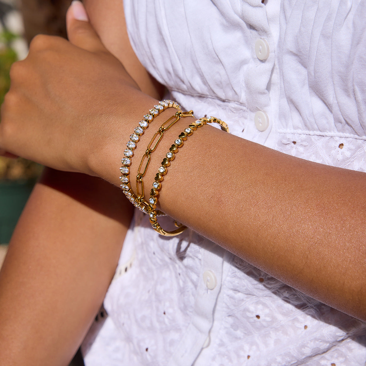 Minimalist gold paperclip chain bracelet styled on wrist in summer light