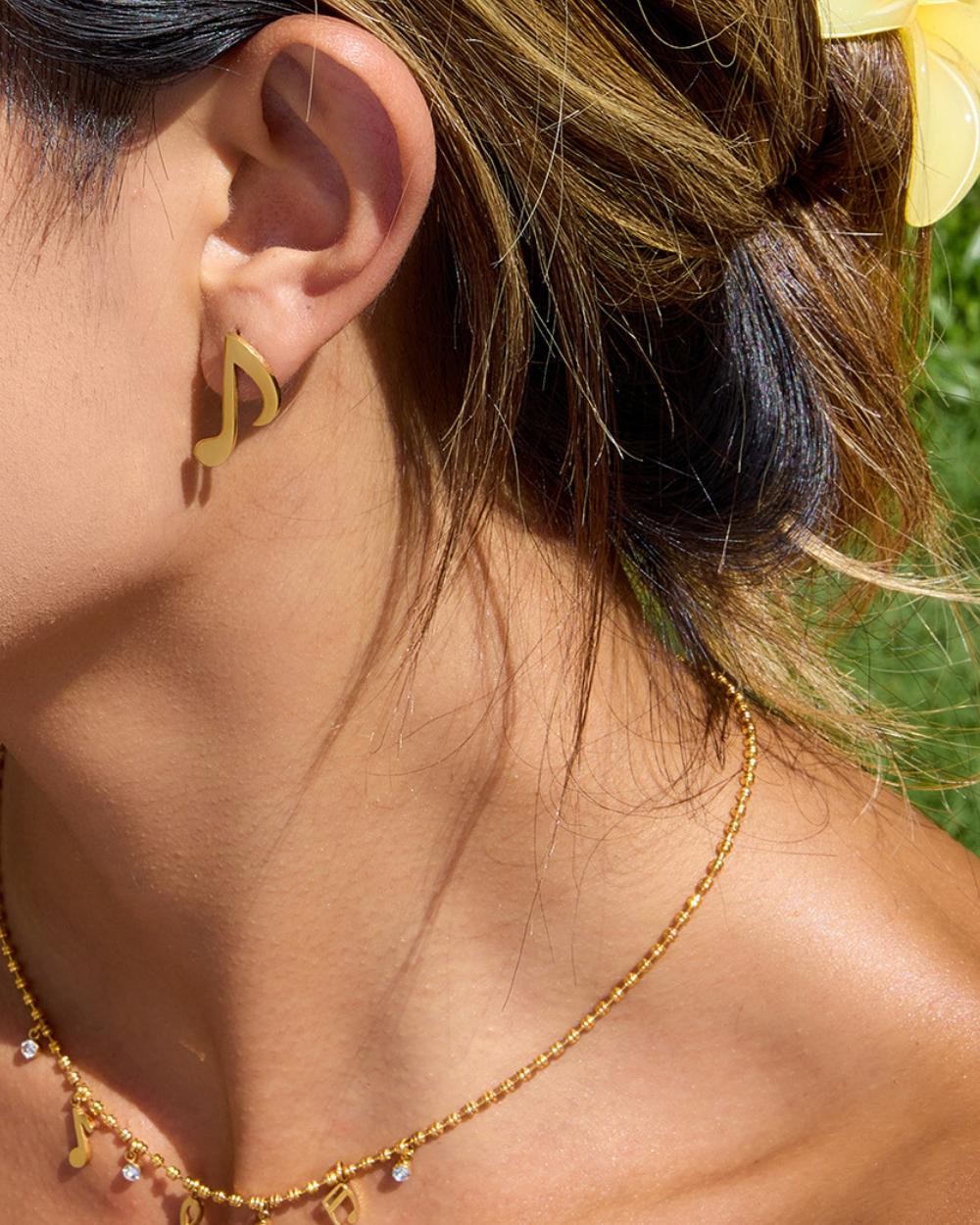 Gold earring with '14k Gold' marking and text about durability on a white background