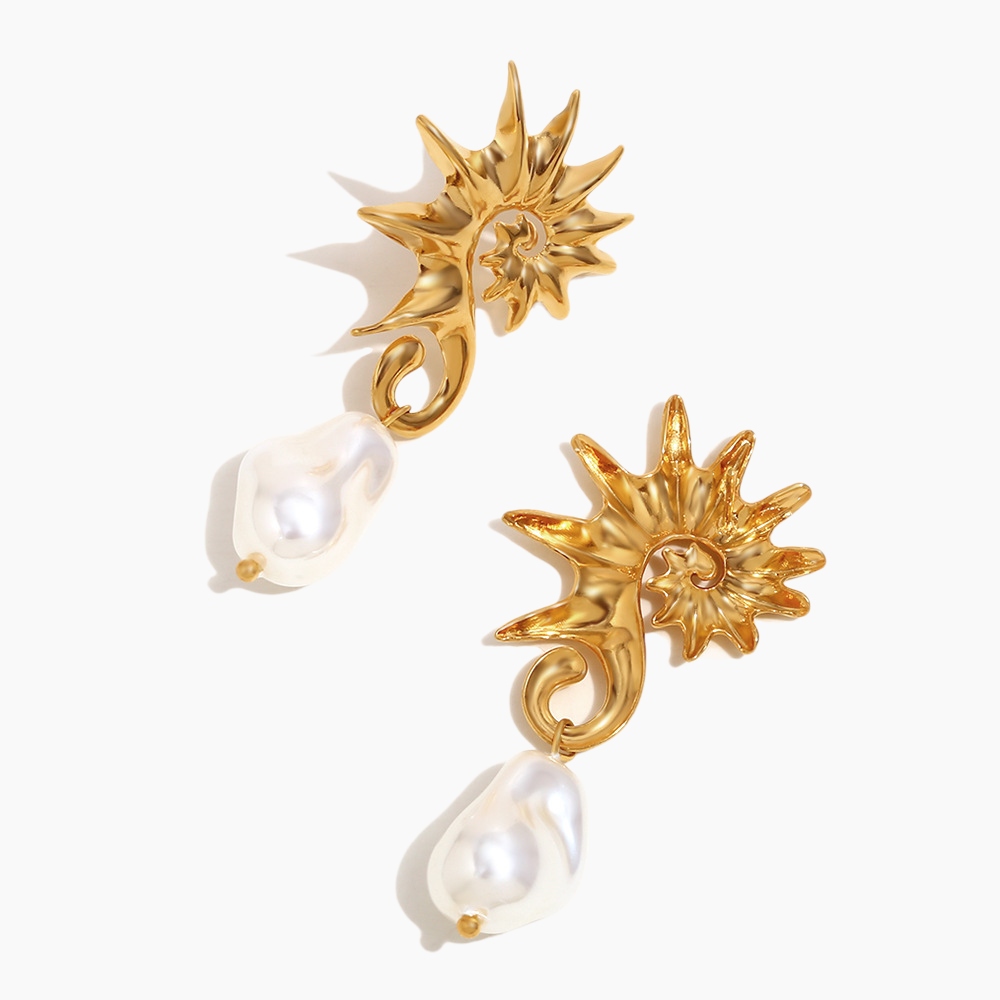 Gold earrings with star-like designs and pearl drops on a white background