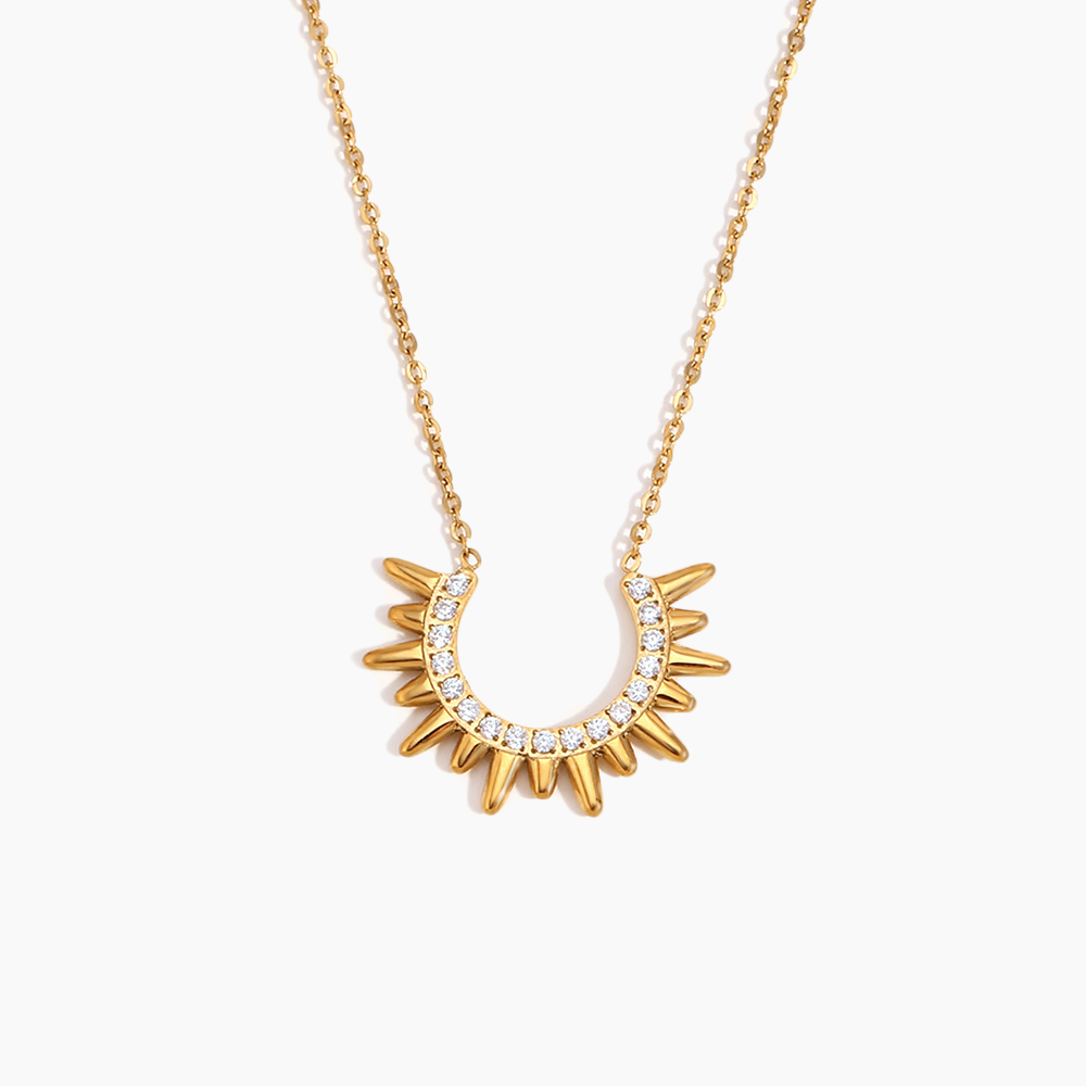 Gold necklace with a sunburst design on a white background