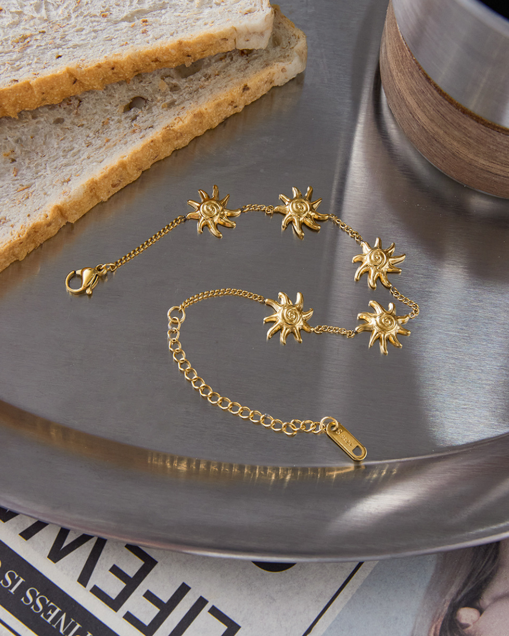 Gold bracelet with sun designs on a metallic surface