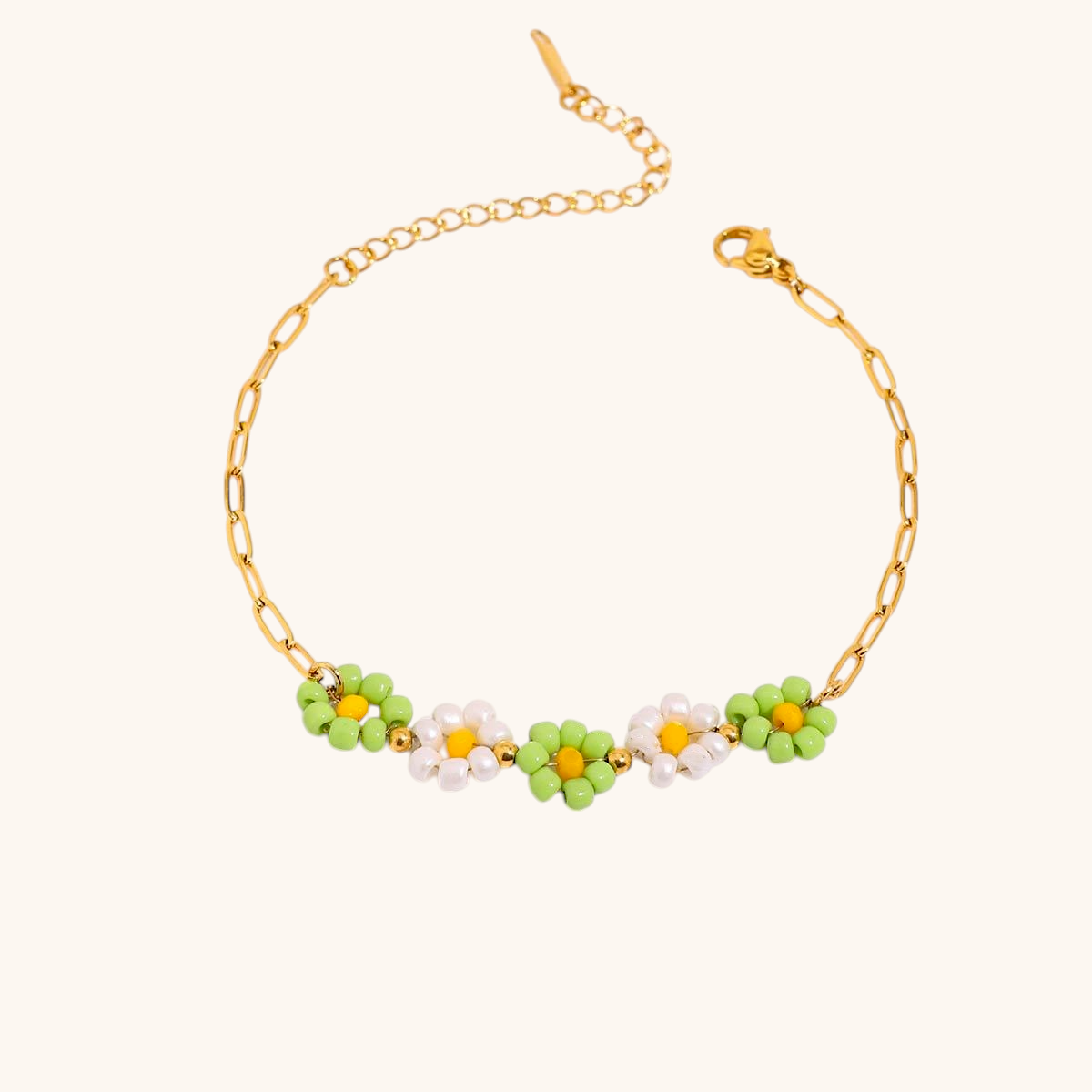 Green and white daisy chain bracelet displayed with fresh pink roses