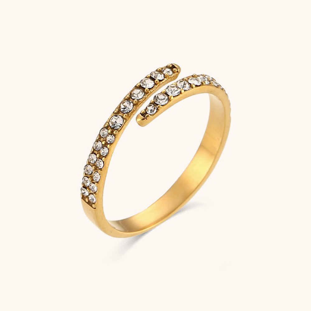 Close-up of sparkling open band gold ring with pavé crystal accents