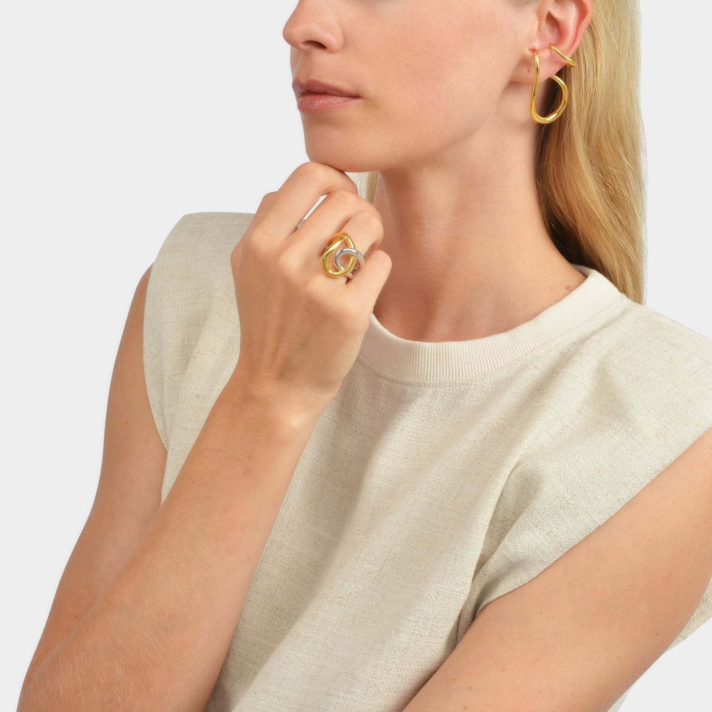 Fashionable woman wearing a silver and gold statement ring with matching earrings