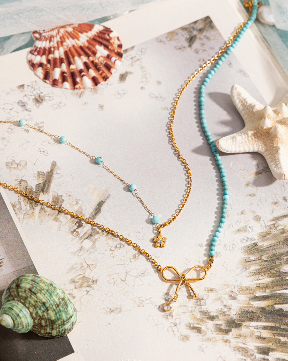 Necklace with a bow pendant on a textured surface with shells and starfish