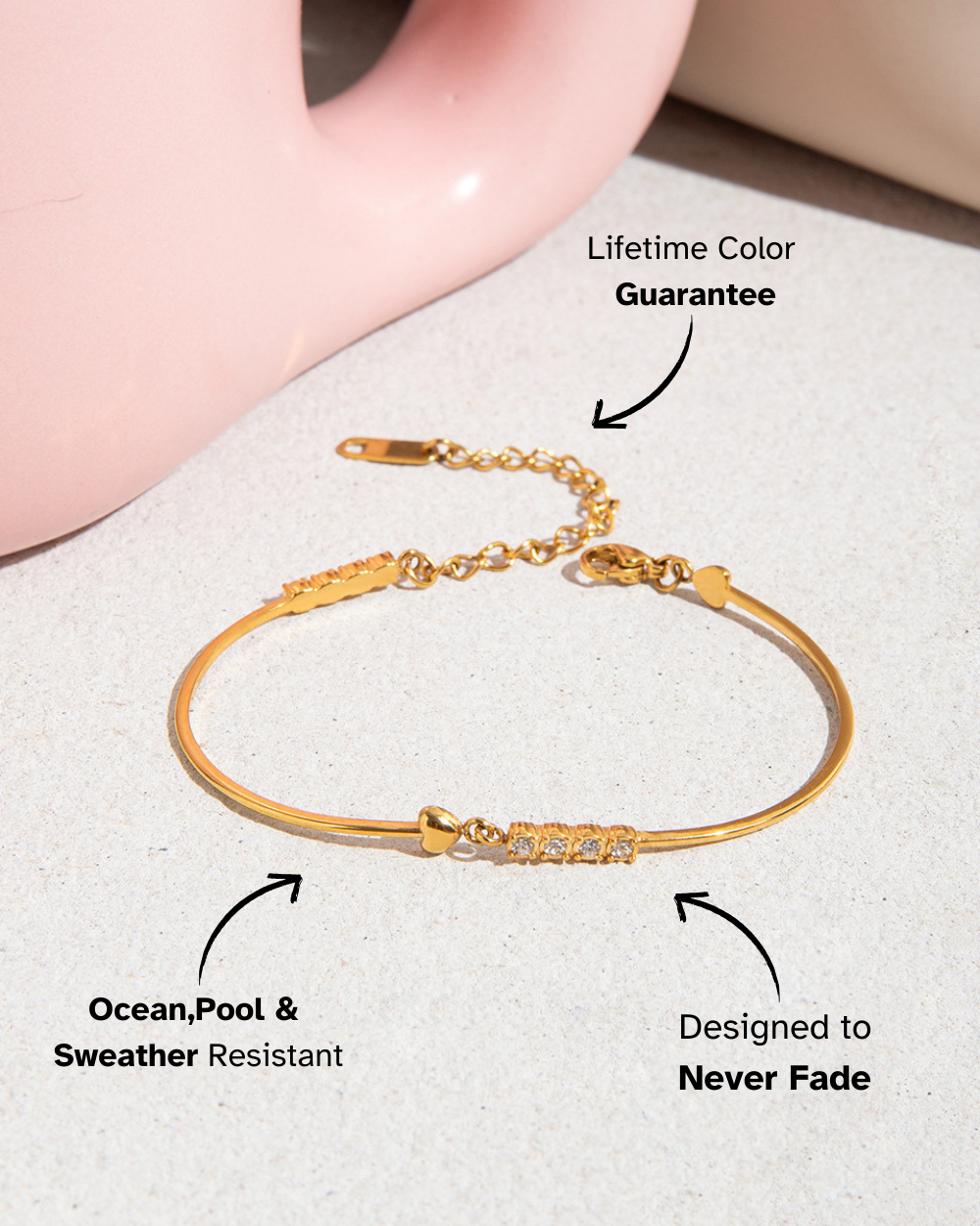 Gold bracelet on a light surface with text highlighting features