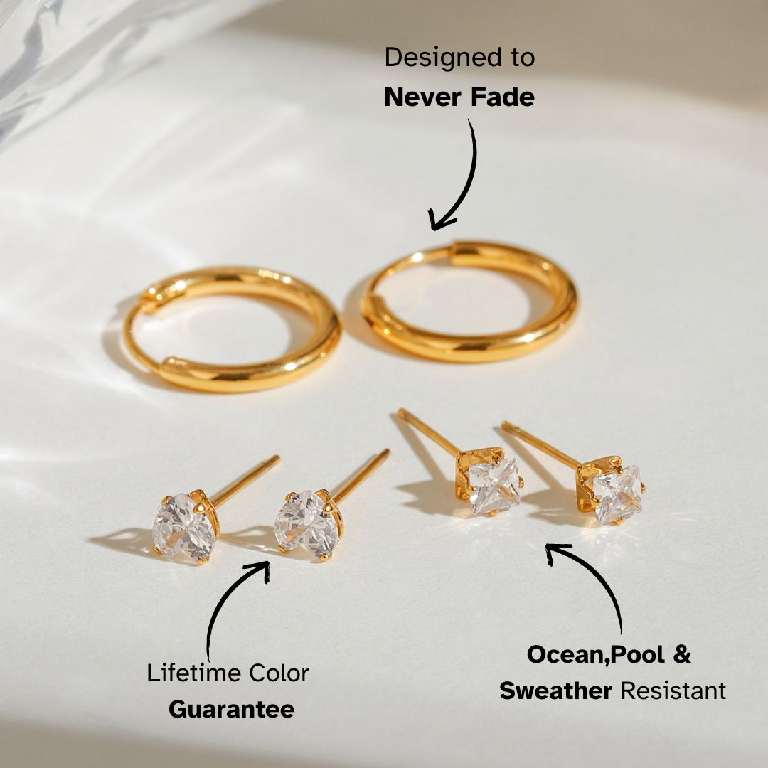 Artistic jewelry display of round gold hoops and crystal stud earrings on light stone