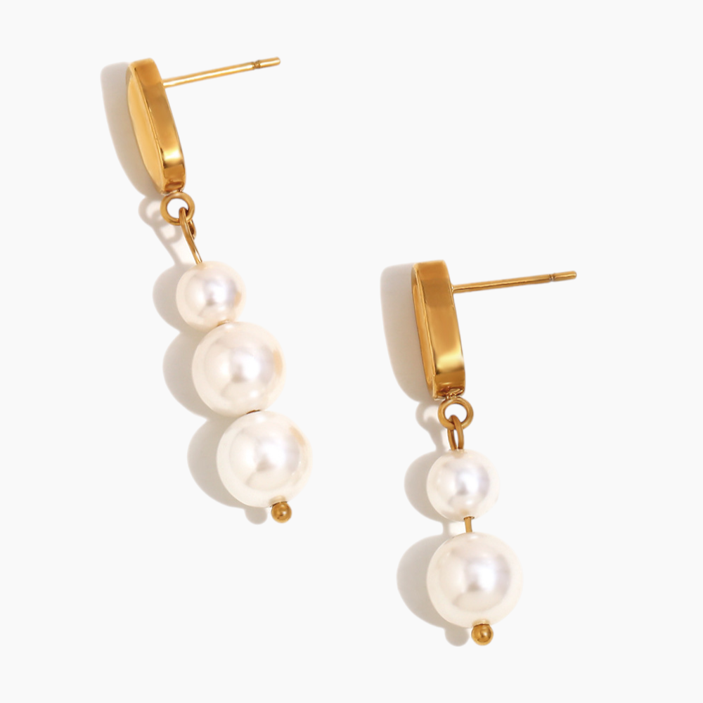 Model wearing elegant pearl drop earrings styled with evening dress