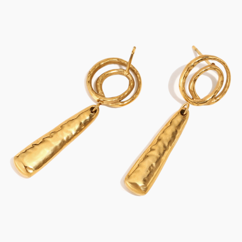 Flat-lay of elegant gold spiral earrings on neutral textured background