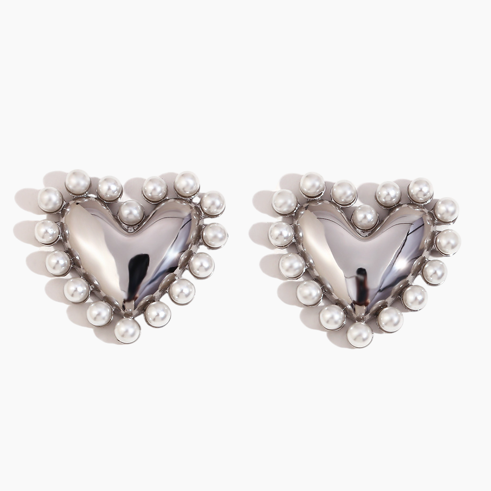 Heart-shaped earrings with pearl details on a white background