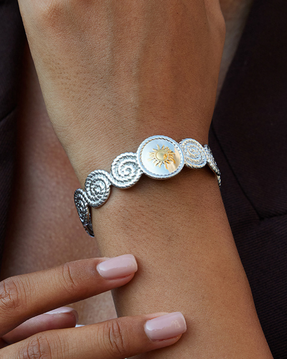 Silver bracelet with decorative elements on a wrist