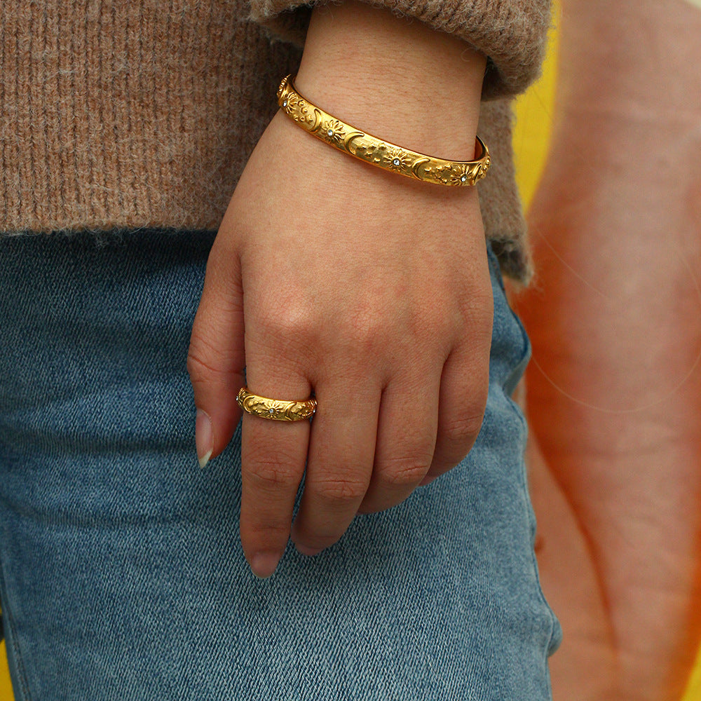 Model showcasing detailed gold floral bracelet with celestial elements for everyday layering