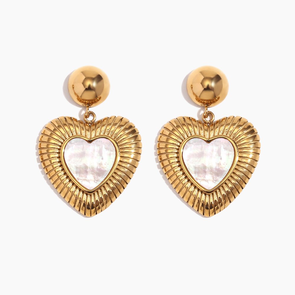 Heart-shaped earrings with gold frames and white centers on a light gray background