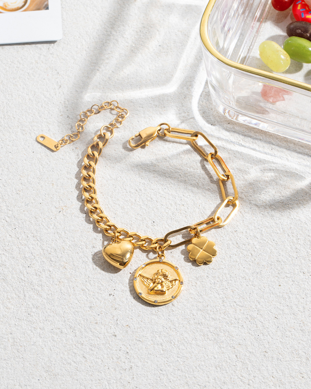 Gold chain bracelet with charms on a white surface