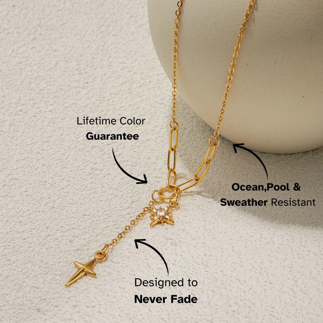 Gold necklace with charms on a light gray background, featuring text about its features.