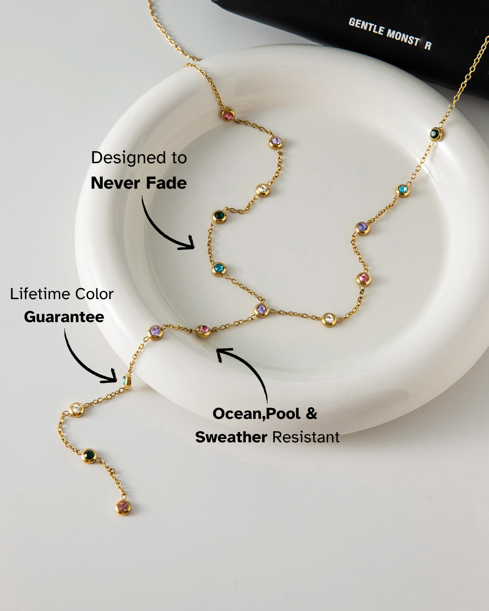 Gold necklace with colored beads on a white dish, featuring text about its features.