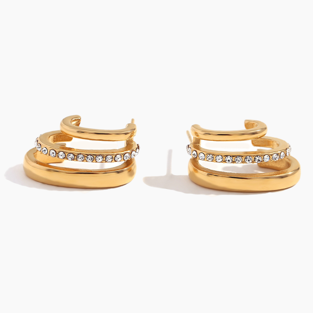 Pair of gold hoop earrings with embedded crystals on a white background