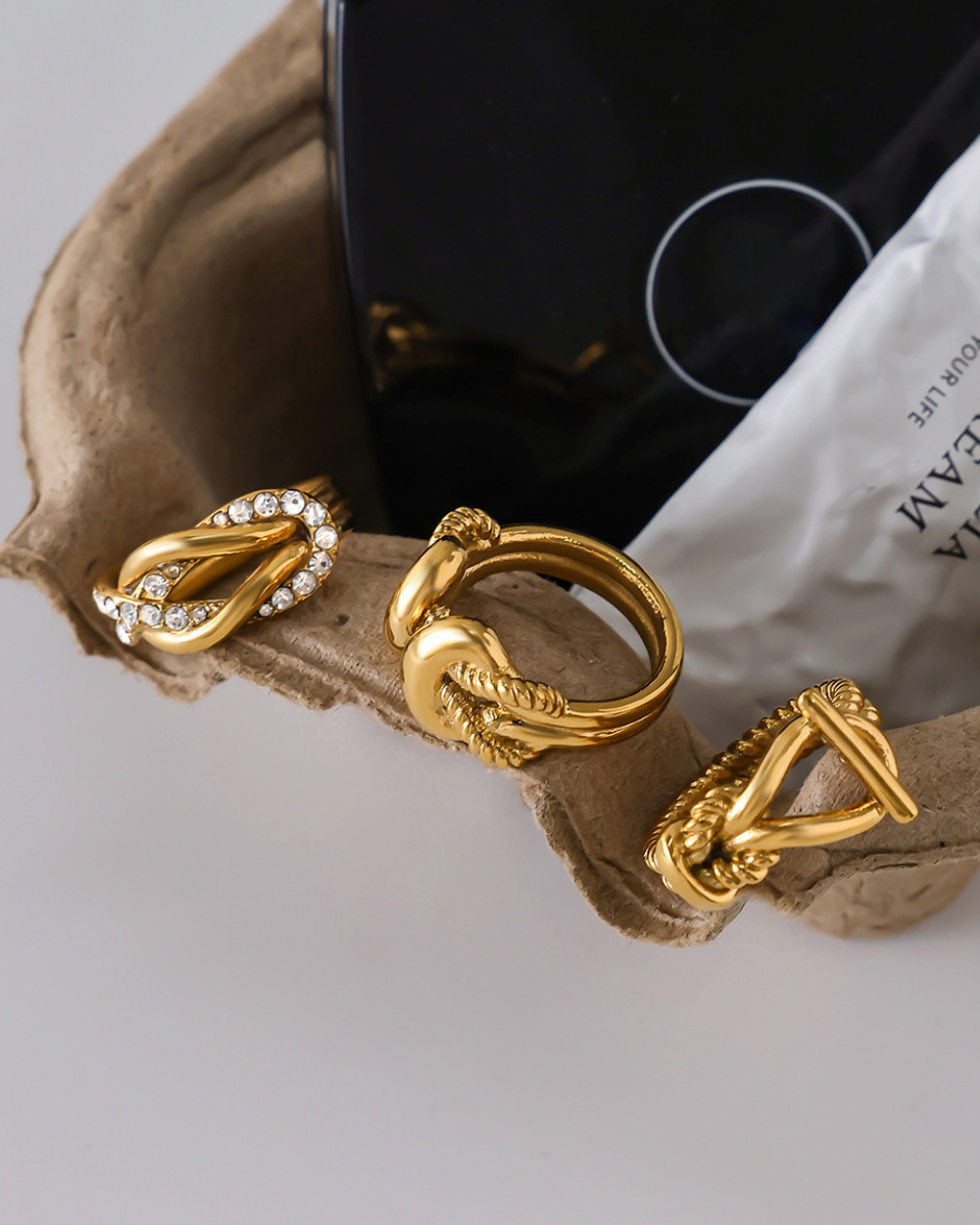 Gold hoop earrings on a textured surface with a blurred background