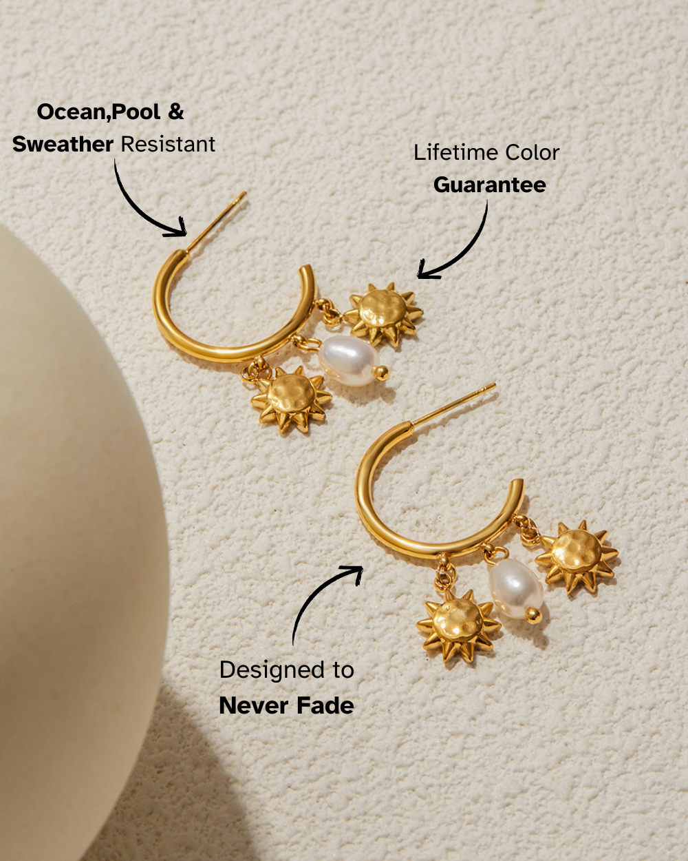 Gold earrings with pearl and sunflower designs on a textured beige background