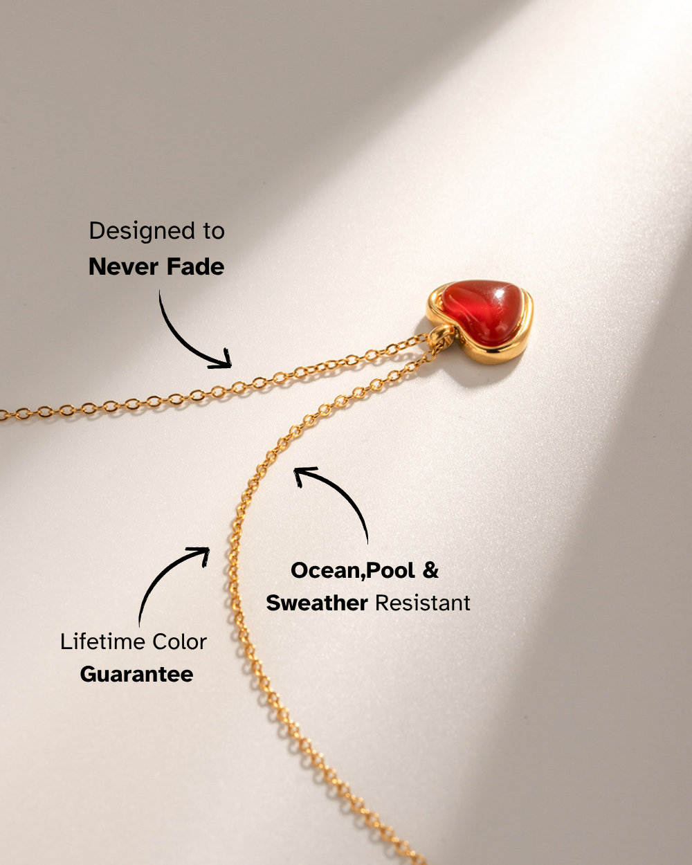 Gold necklace with a red pendant on a light background