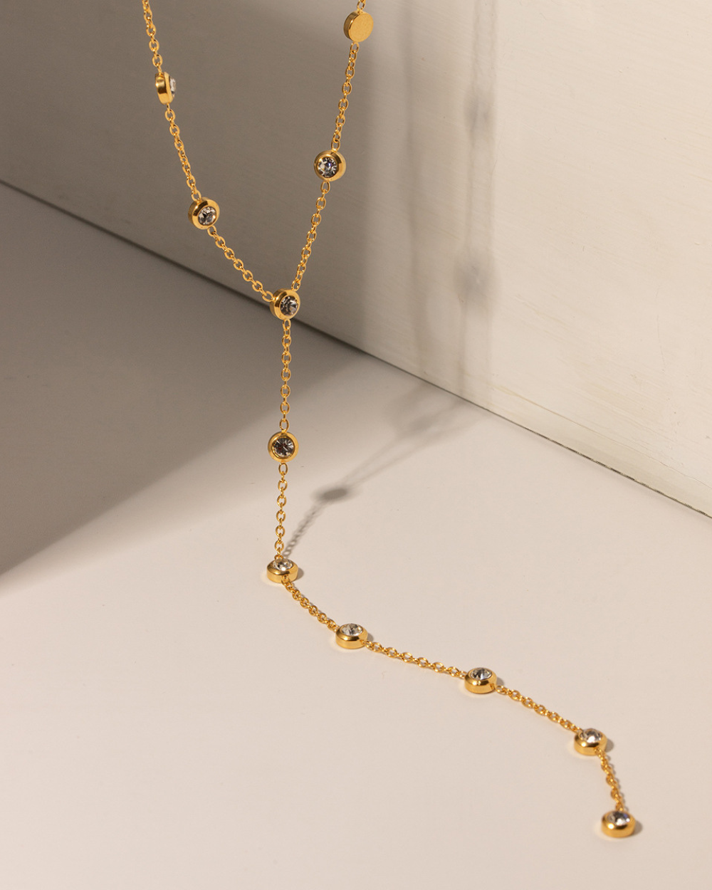 Gold necklace with black stones on a neutral background