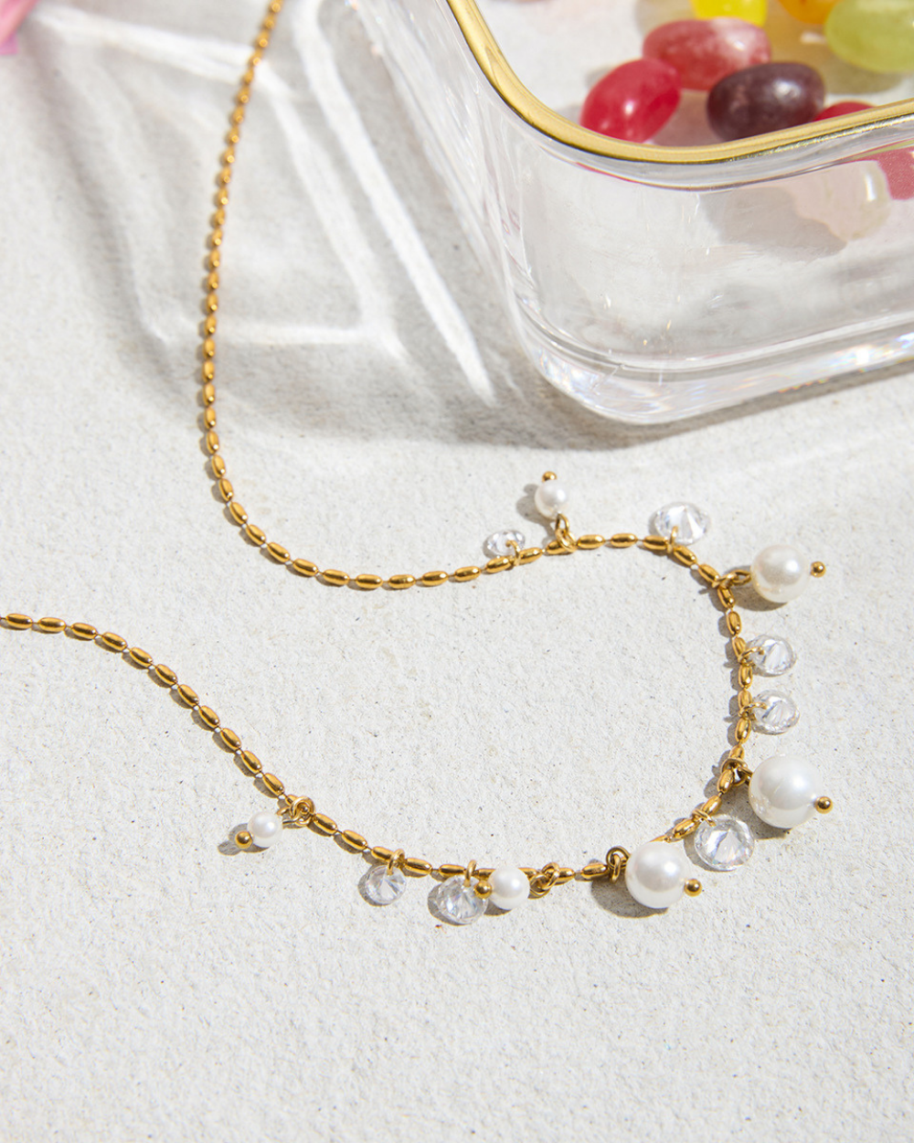 Gold necklace with pearls on a white surface