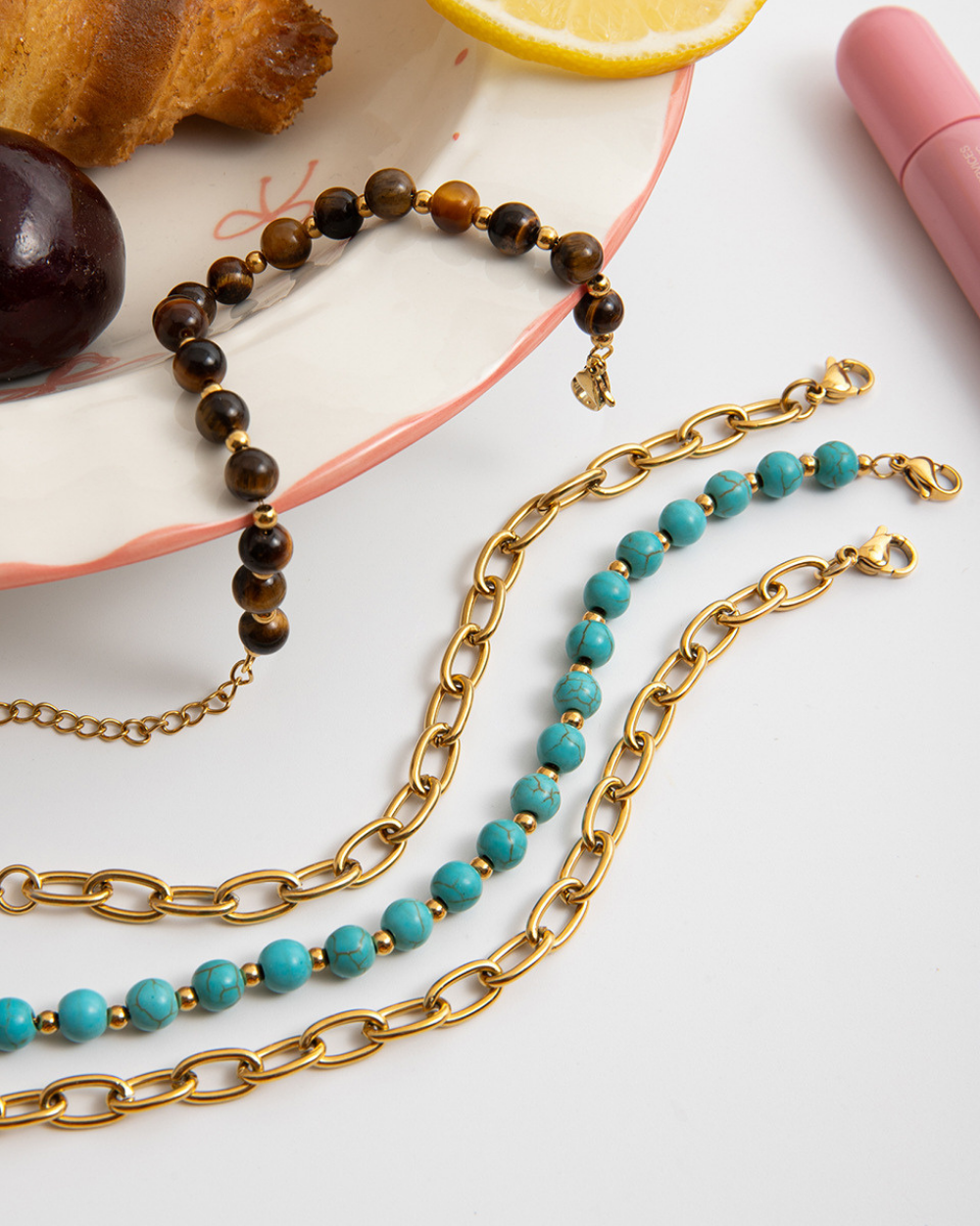 Three necklaces with different designs on a white surface.