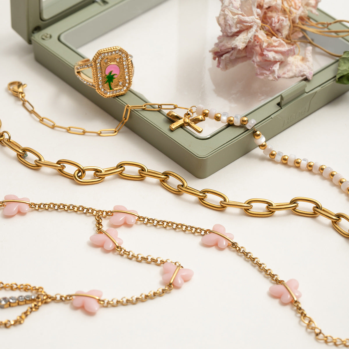 Flat lay of pink butterfly hand bracelet with gold chain, whimsical summer jewelry