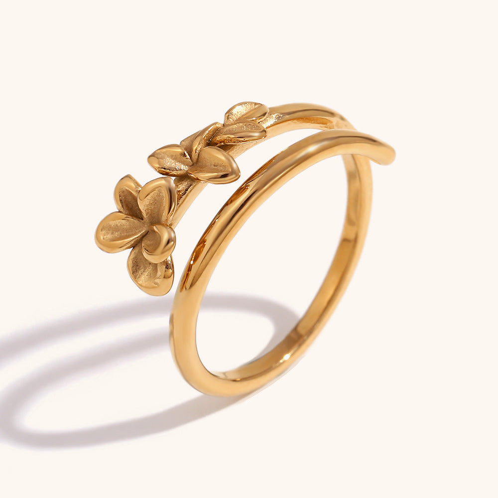 Close-up of open gold ring with delicate flower design, perfect for stacking
