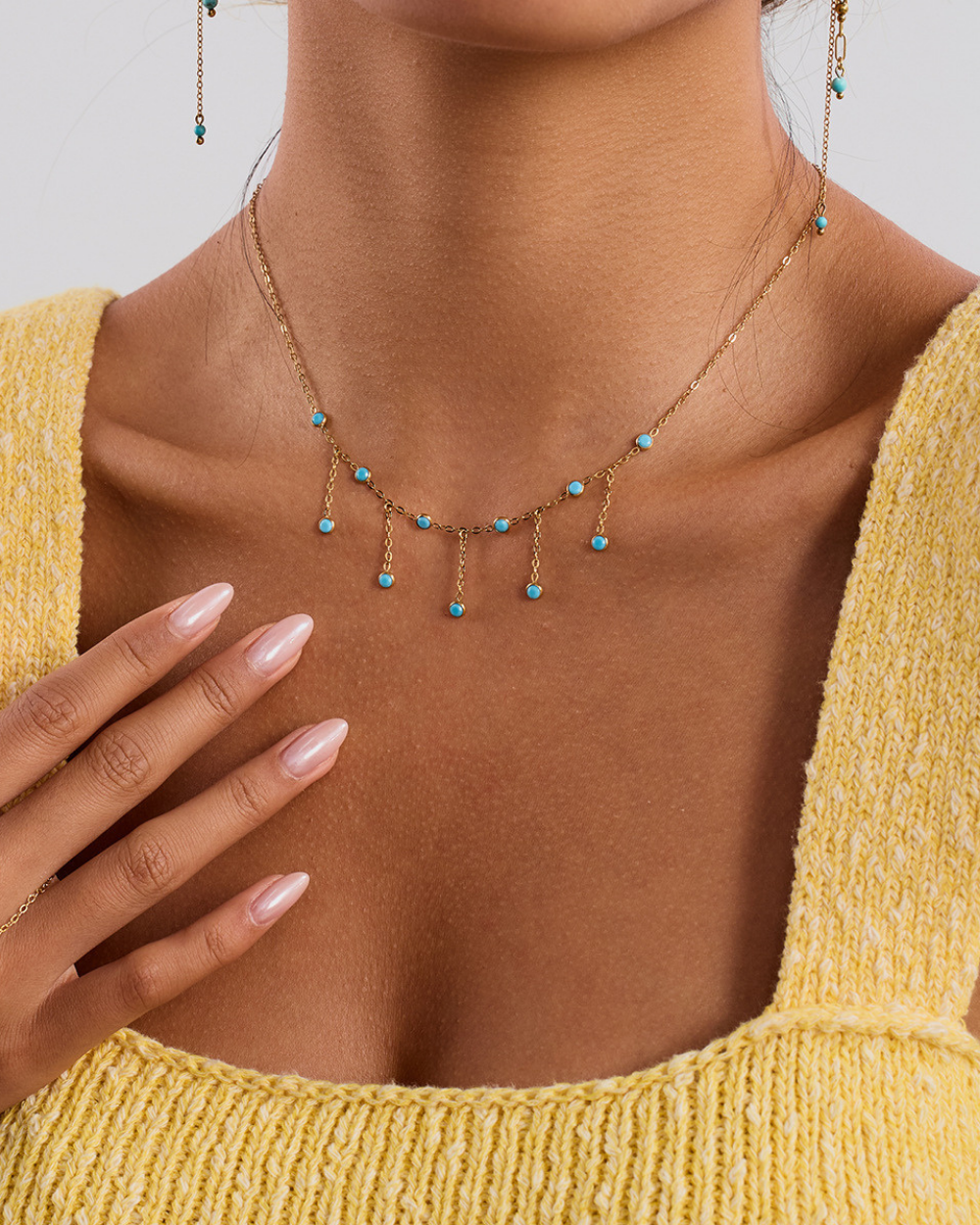 Necklace with turquoise beads worn by a person in a yellow top