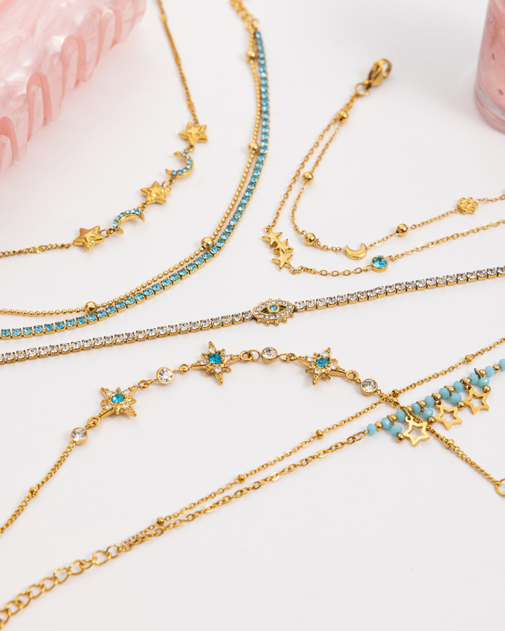 Gold and turquoise beaded necklaces on a white surface