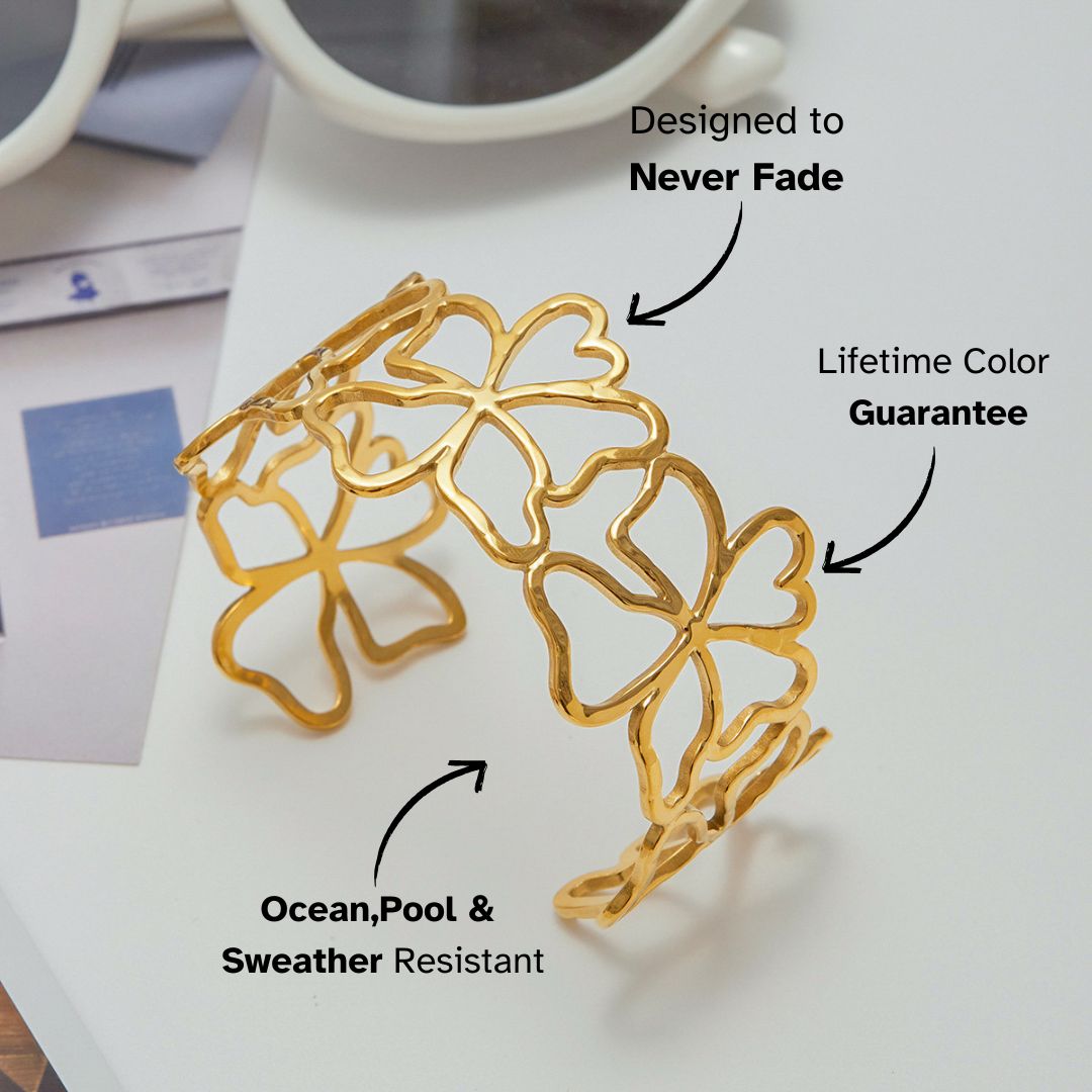 Gold clover open cuff bracelet styled with white sunglasses on table_MiFJewelry