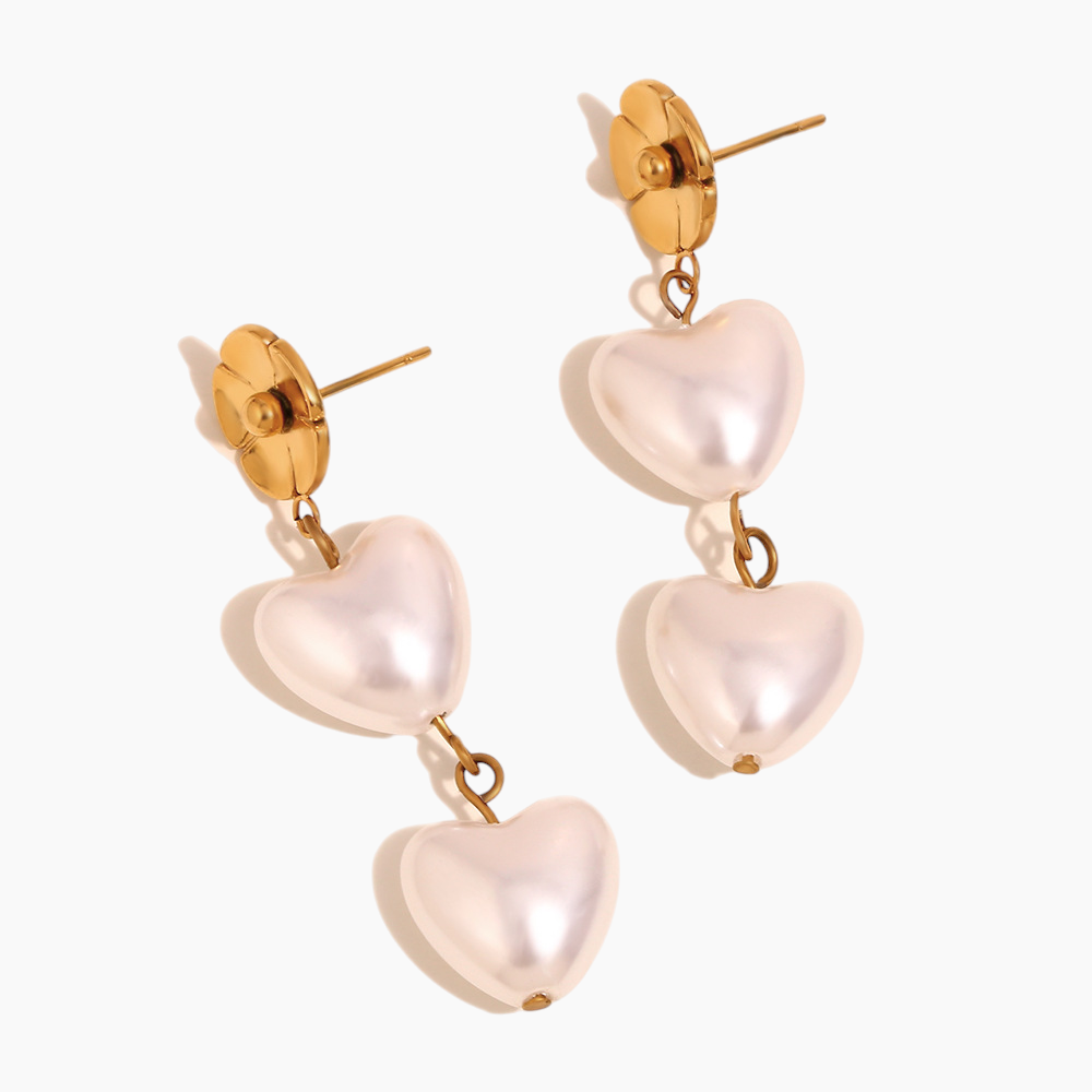 Close-up of blossom heart pearl earrings with gold-plated finish