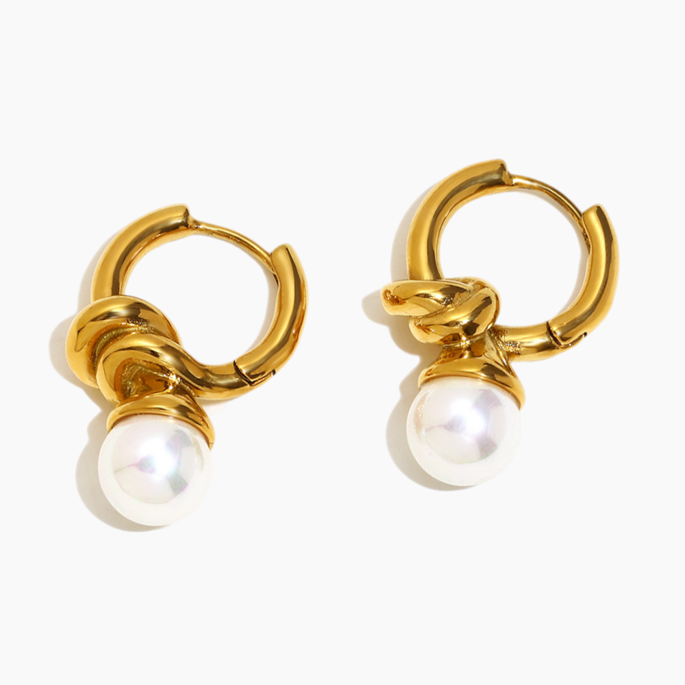Gold hoop earrings with pearl drops on a white background