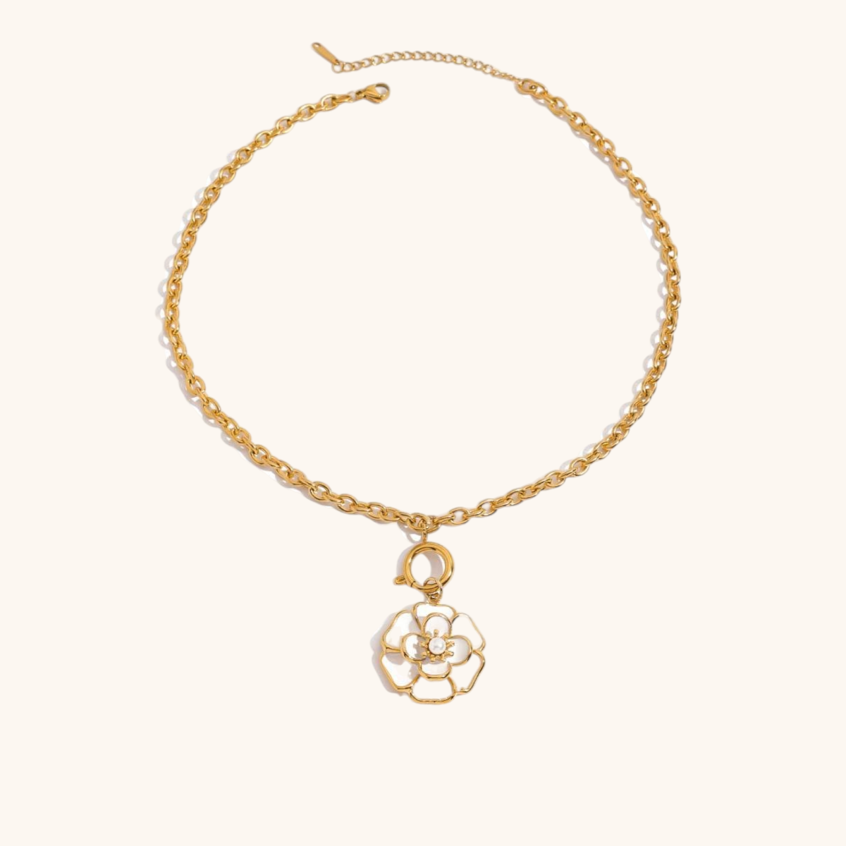 Minimalist product photo of gold necklace with hanging enamel flower charm