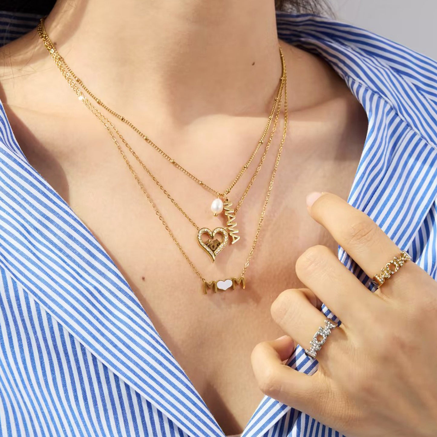 Close-up of double mom rings and heart pendant necklace, gold and silver mix