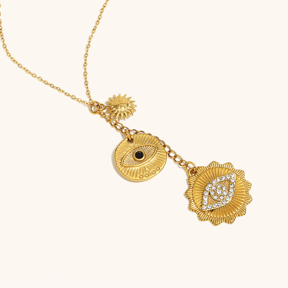 Flat lay of triple pendant gold necklace on ivory background