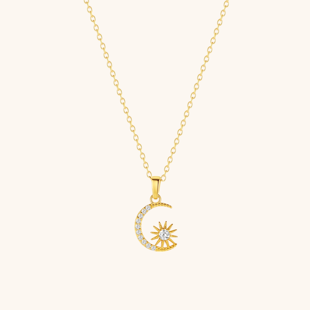 Dainty celestial charm necklace with moon and star on soft beige surface, minimal style.