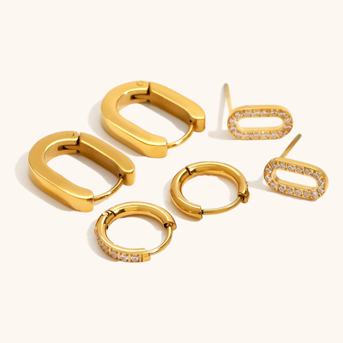 Close-up of gold oval pavé stud earrings with sparkling CZ stones