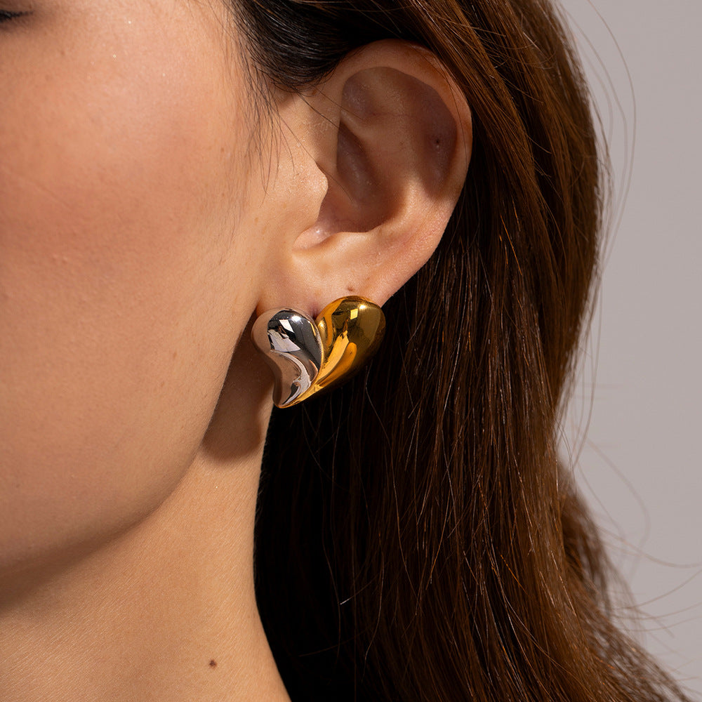 Model wearing mixed gold and silver heart earrings, close-up on ear and jawline
