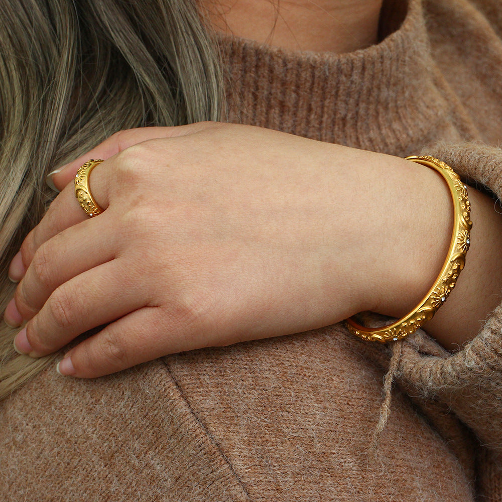 Model wearing floral gold cuff bracelet styled with a warm knit sweater