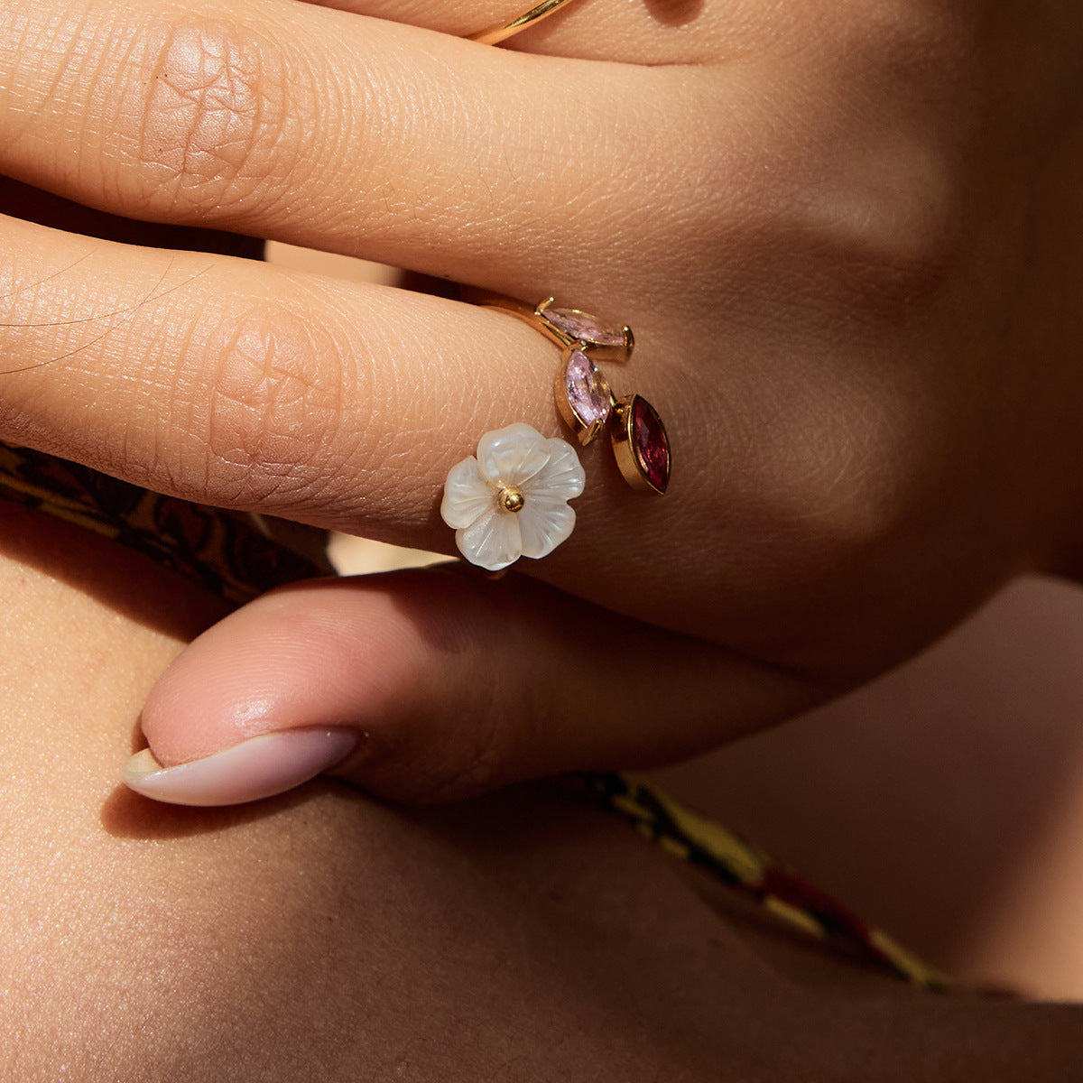Summer floral ring on hand with flower branch in outdoor sunlight