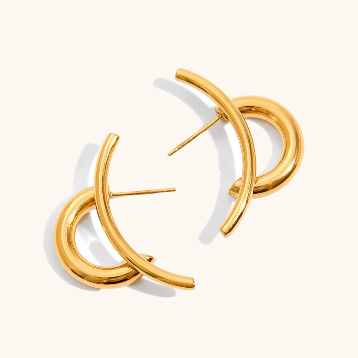 Close-up of gold crossover hoop earrings on a white background